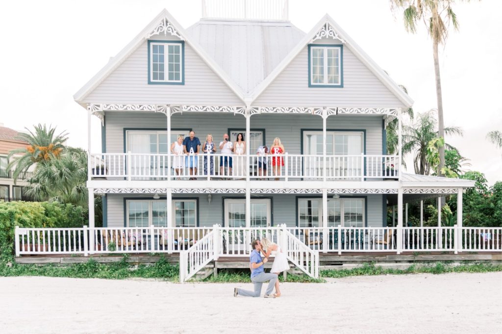 She said yes! On this Clearwater beach on the Florida coast, the surprise proposal went extremely well. White fenced Clearwater beach house made for a great background and viewing station for friends and family. #surpriseproposal #4thofjuly #independencedayengagement #familyandfriends #floridabeach #beachproposal #proposaldetails #proposal #marryme #shesaidyes #redwhiteandblueproposal