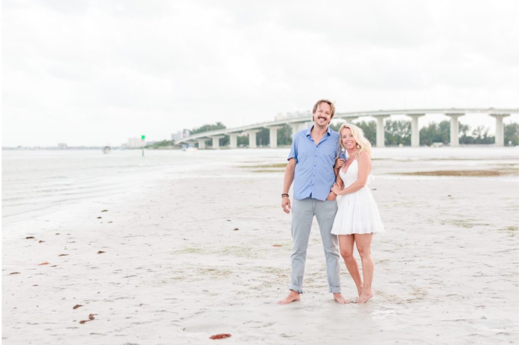 His blue button down shir and pants were the perfect complement to her white textured dress. They looked fantastic for their surprise proposal! #surpriseproposal #4thofjuly #independencedayengagement #familyandfriends #floridabeach #beachproposal #proposaldetails #proposal #marryme #shesaidyes #redwhiteandblueproposal