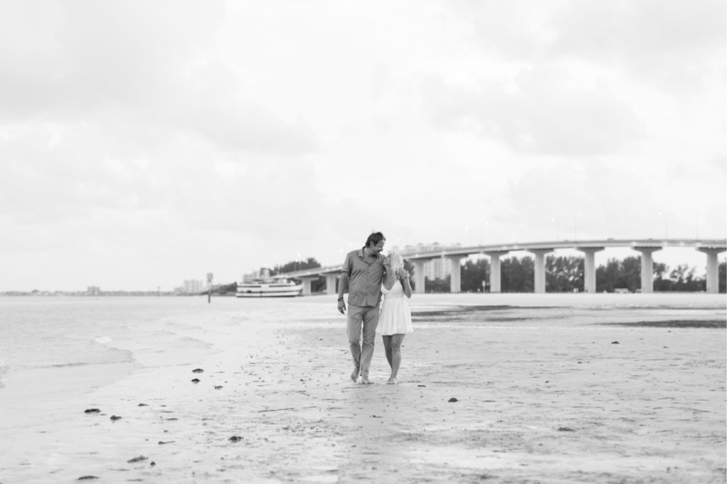 Sweet black and white photo of this happy couple sharing a kiss to celebrate the beginning of their engagement! #surpriseproposal #4thofjuly #independencedayengagement #familyandfriends #floridabeach #beachproposal #proposaldetails #proposal #marryme #shesaidyes #redwhiteandblueproposal