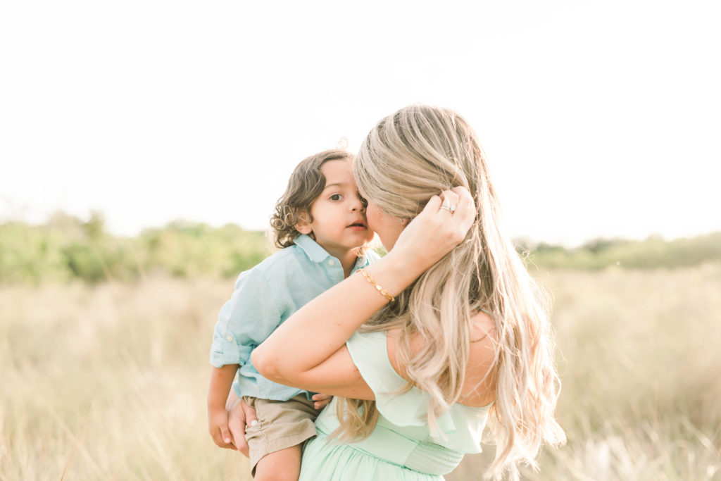 Mommy kissed at son's cheek.