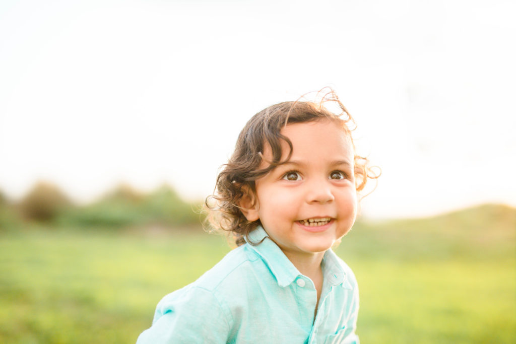 The boy is smiling at golden hour.