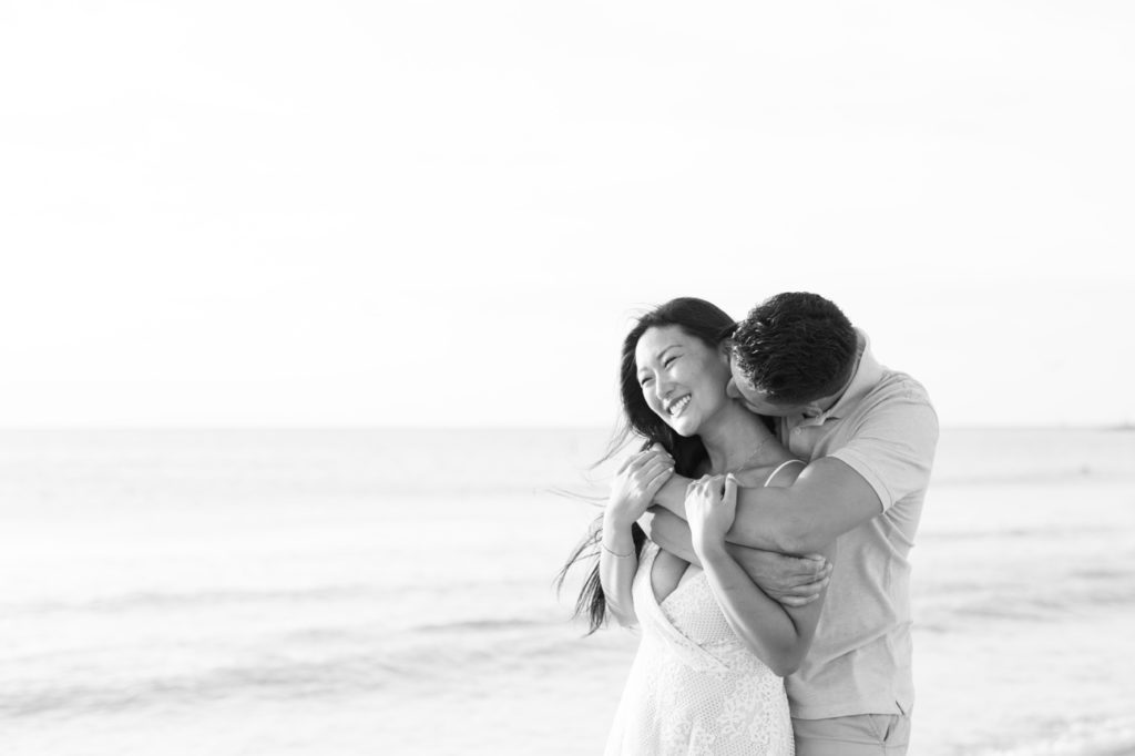 Couple giggles on their engagement beach photos.