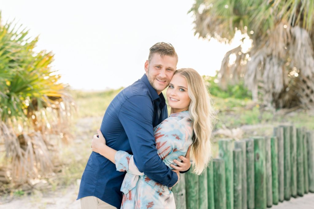 Couple look at camera before their sunset beach engagement session