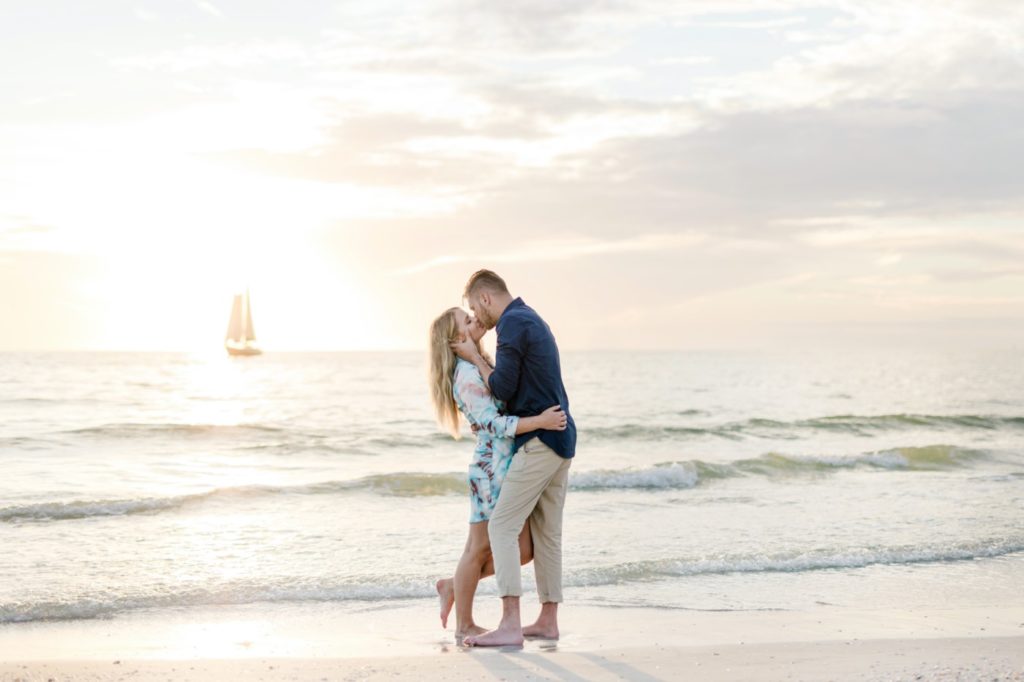 Beautiful couple kissing on the sunset beach engagement session