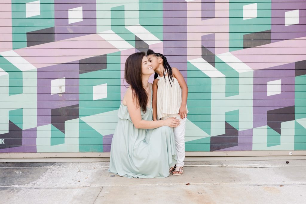 A daughter is kissing her mom at Hyde Park Village Tampa.
