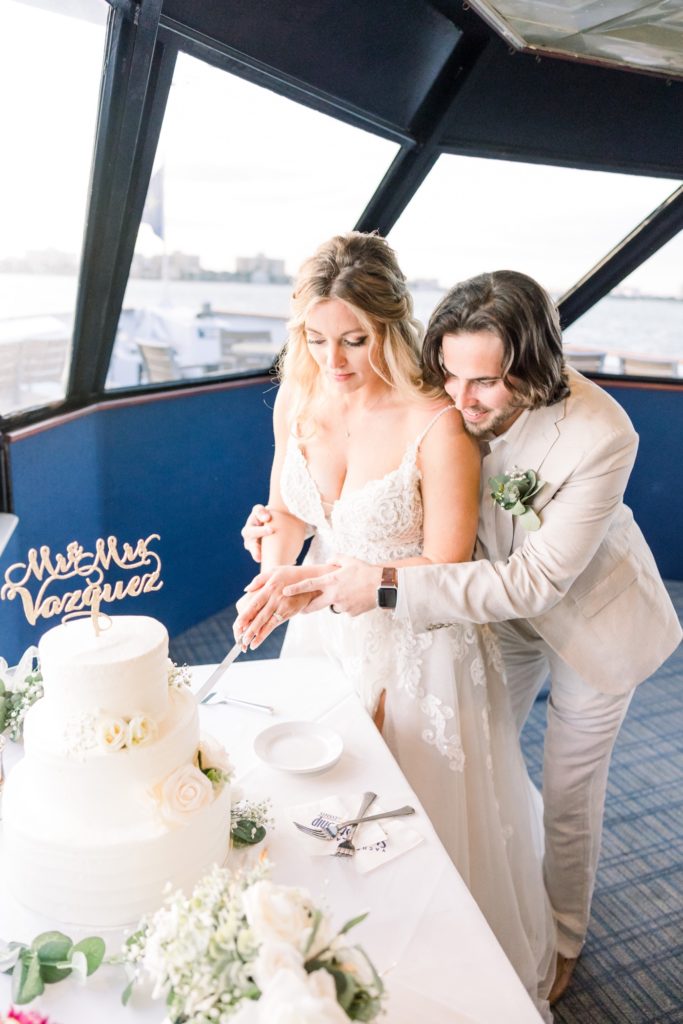 Bride and Groom are cutting cake on the Yacht StarShip IV Sunset Cruise