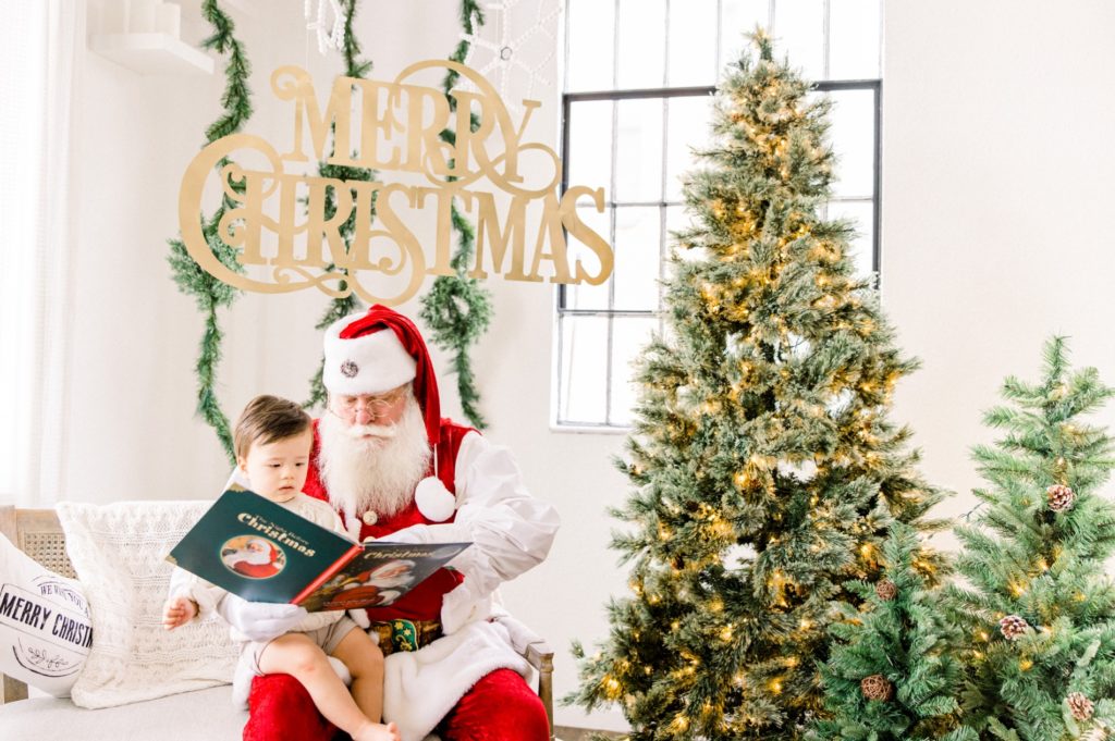 Santa read a book for the boy  in the Santa Mini Sessions for Holiday photos.