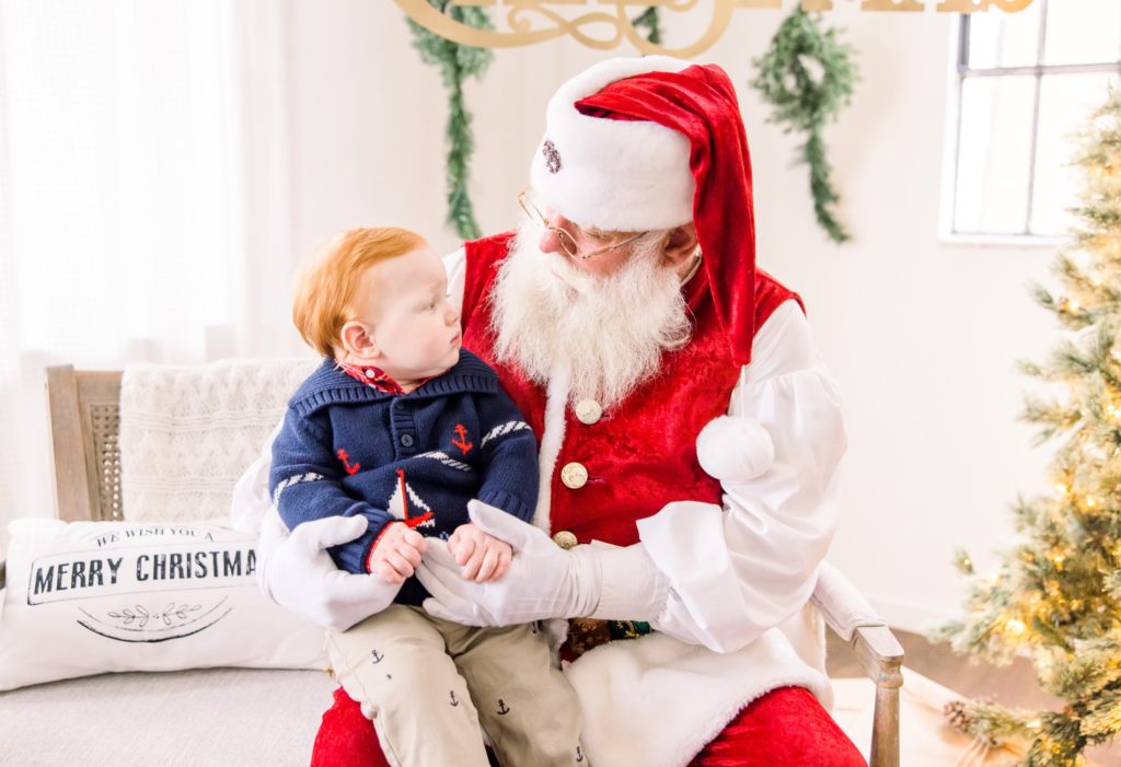 A little boy was so curious about Santa Claus in Town in the Santa Mini Sessions for Holiday photos