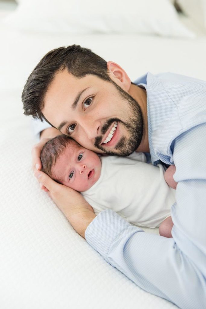 Studio newborn session with a day and baby snuggling by Jommy Photography in Florida. daad and baby with eyes open brown eyes #JommyPhotography #JommyFamilies #FloridaFamilyPhotography #Familyphotographers #professionalphotographers #familyportraits