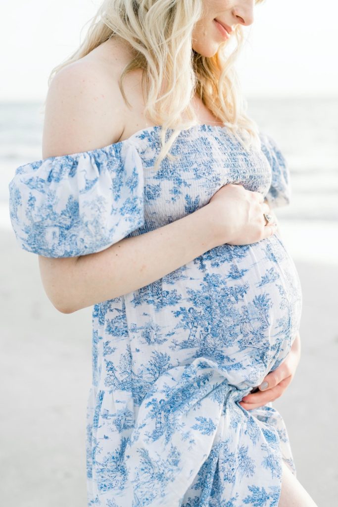 Close-up of a woman holding her maternity bump at a beach in Florida by Jommy Photography. Pro Maternity photographer #JommyPhotography #JommyFamilies #FloridaFamilyPhotography #Familyphotographers #professionalphotographers #familyportraits