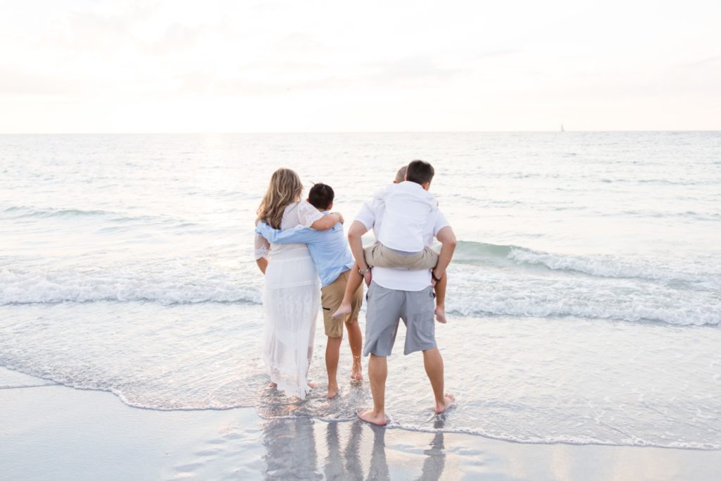 Family photographer Jommy Photography captures a family of four playing in the beach water in Florida. beach family pic #JommyPhotography #JommyFamilies #FloridaFamilyPhotography #Familyphotographers #professionalphotographers #familyportraits