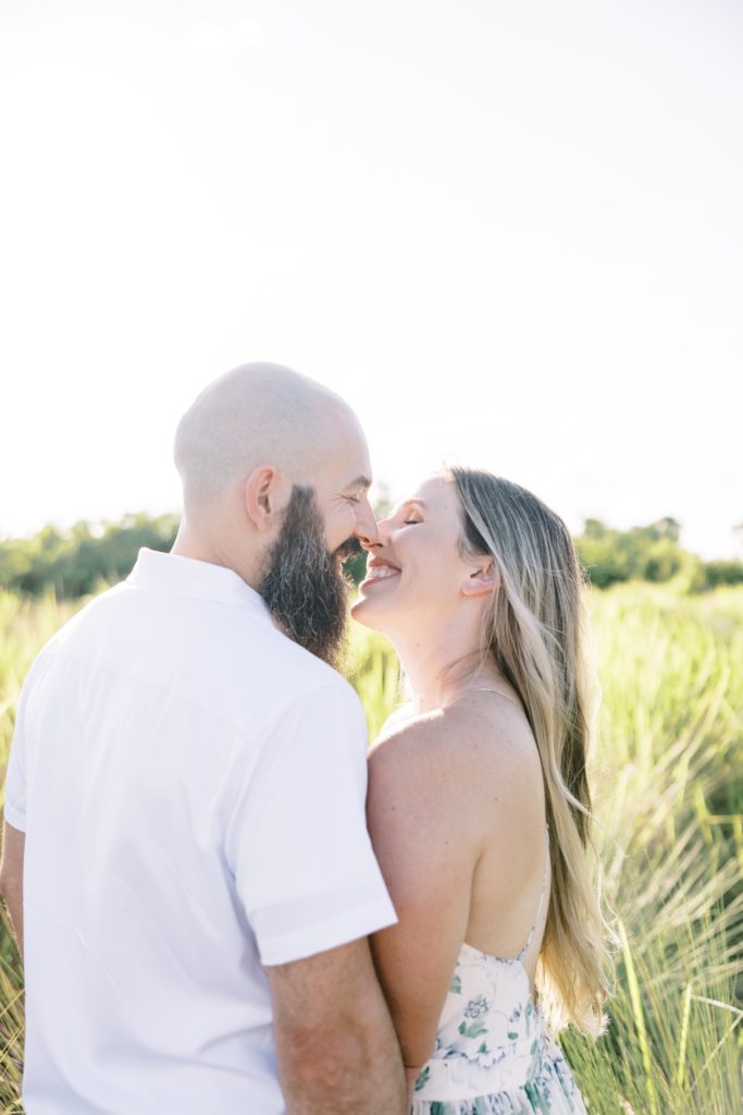 Husband and wife kiss with bright white sunshine behind them by Jommy Photography in Florida. kissing couple #JommyPhotography #JommyCouples #FloridaCouplesPhotography #ProfessionalPhotographer #beachphotographer #couples #romanticcouples